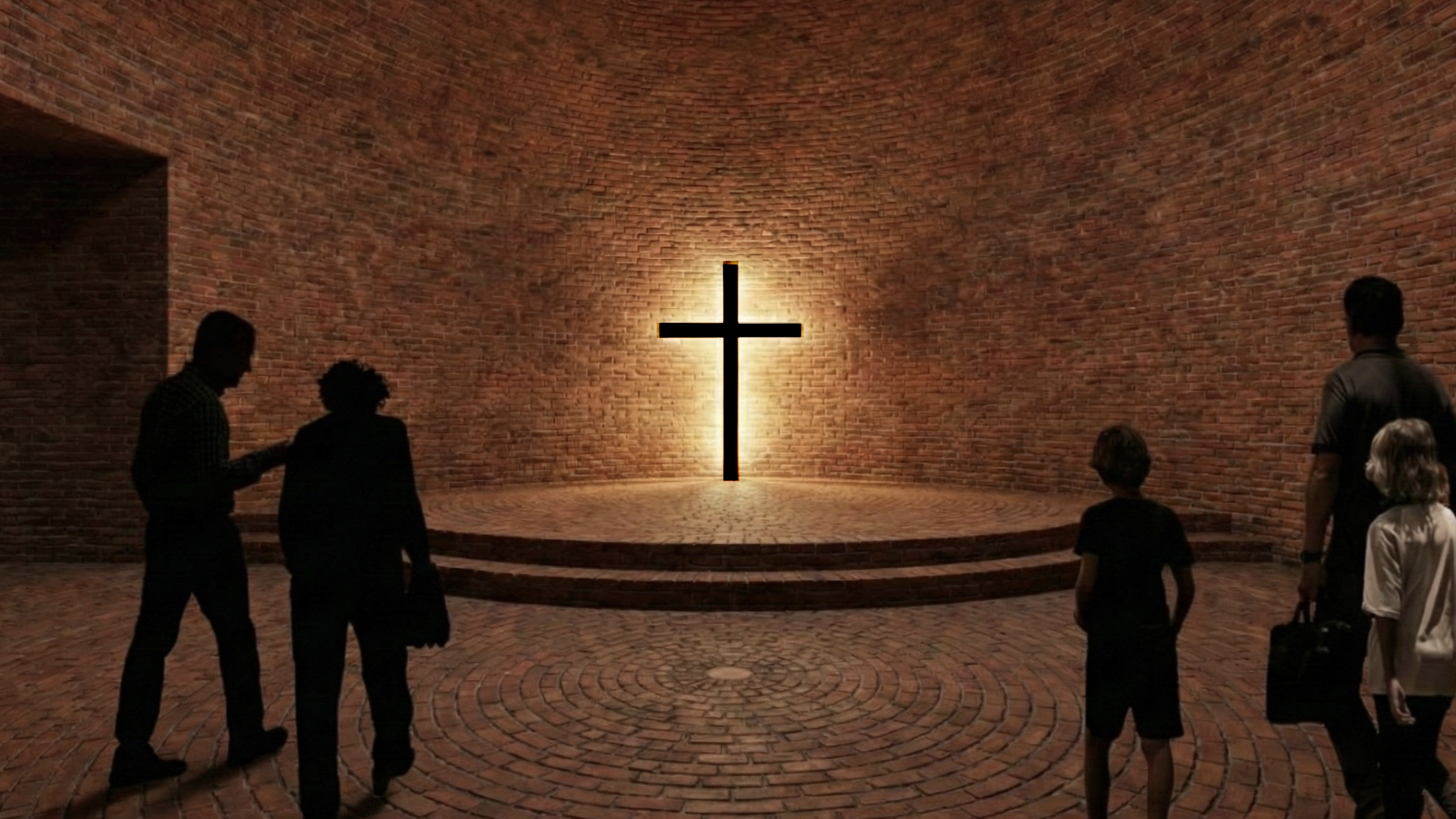 Group of pilgrims facing the altar cross inside a circular brick chapel with concentric brick flooring